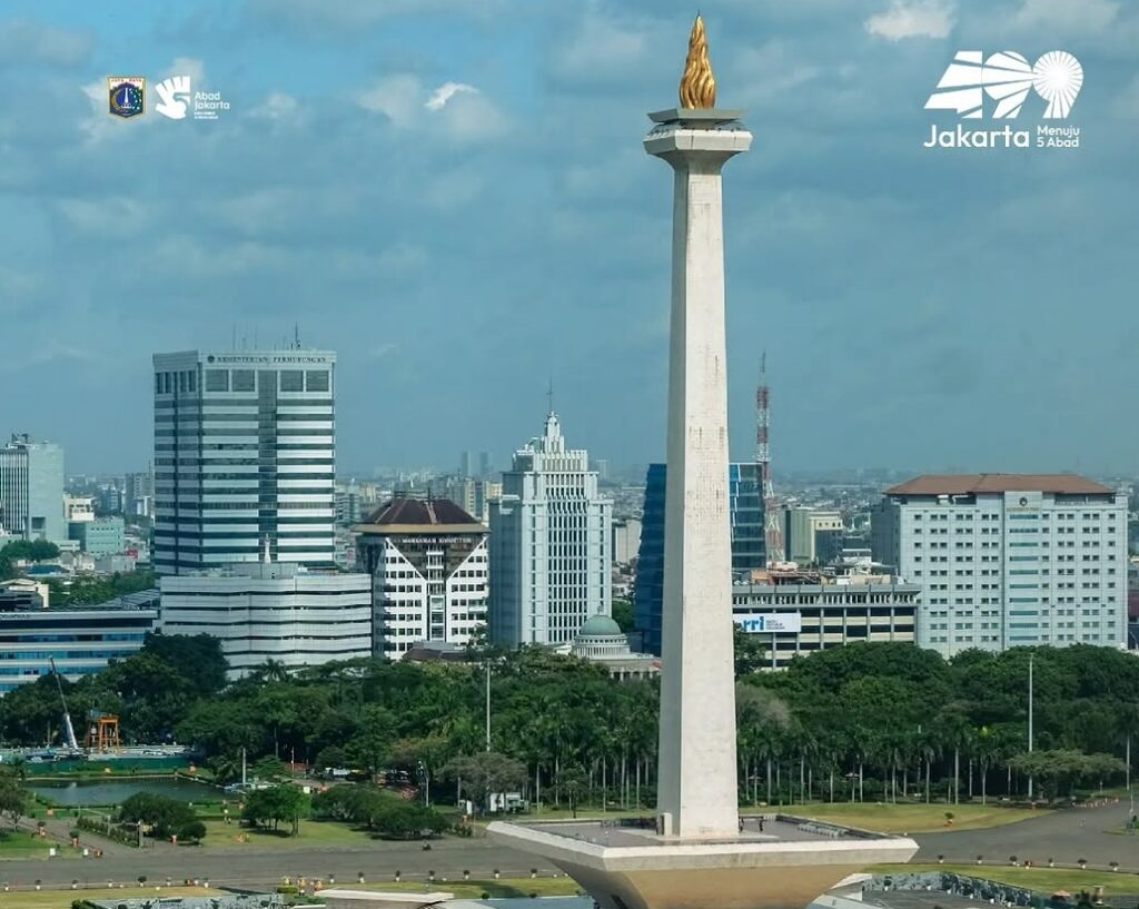 Jakarta menegaskan posisinya sebagai city of cinema catrawarta Tall monas monument rising from a square plaza with the jakarta city skyline and green park in the foreground logos for jakarta and abad jakarta in the sky